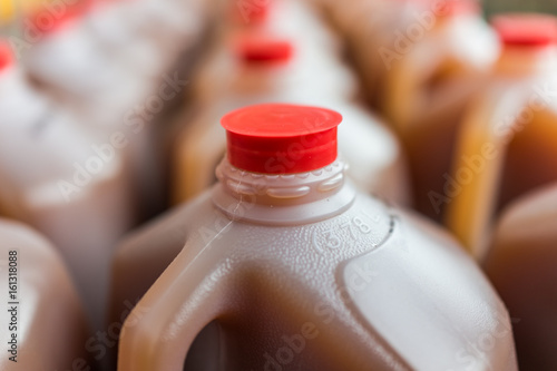 Rows of plastic gallon jars on display filled with apple cider photo