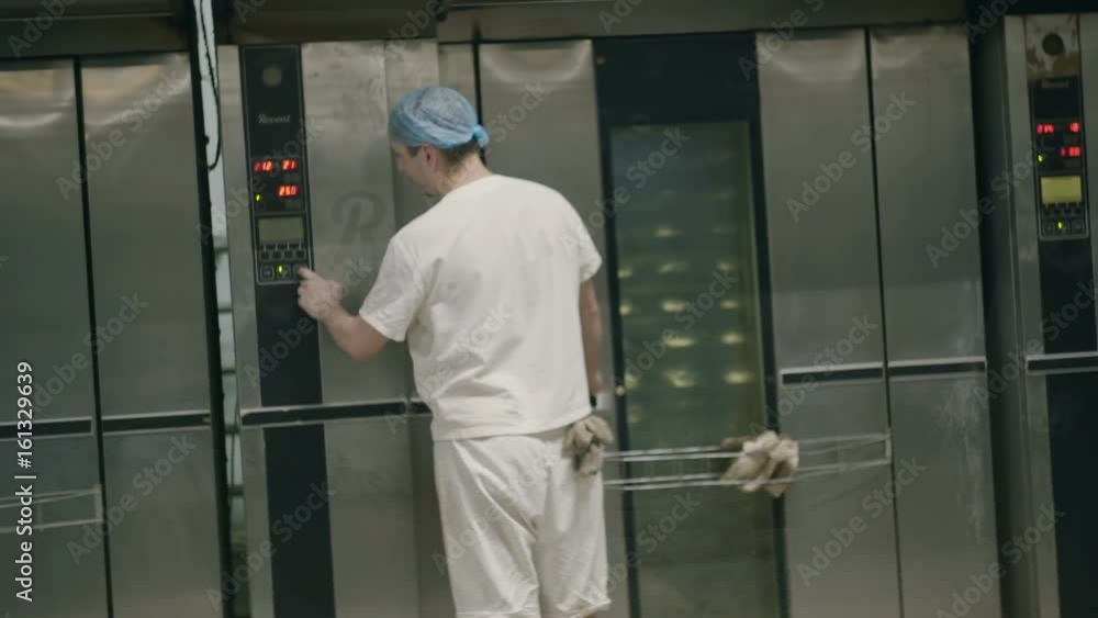 The man puts the bread in the oven and puts it in The man puts the bread in the oven and puts it in