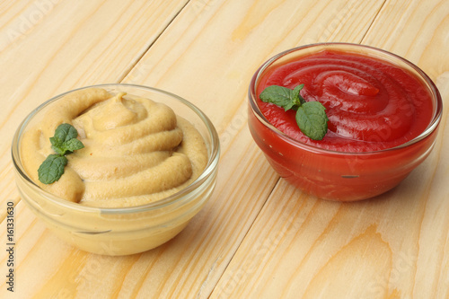 Fotografi mustard ketchup in glass bowl on wooden background.