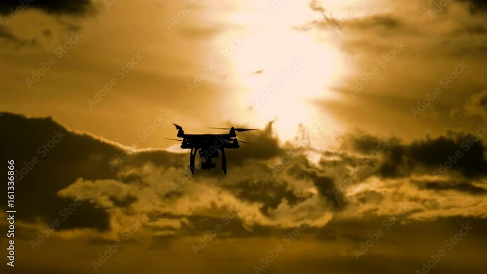 Drone silhouette flying in sunset landscape Drone silhouette flying in sunset landscape