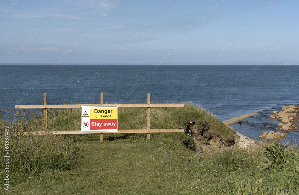 Danger signs on the cliff edge at Peveril Point in Swanage Bay Dorest England UK
