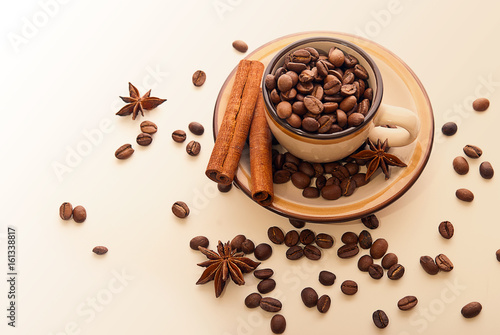 A cup of coffee beans and cinnamon
