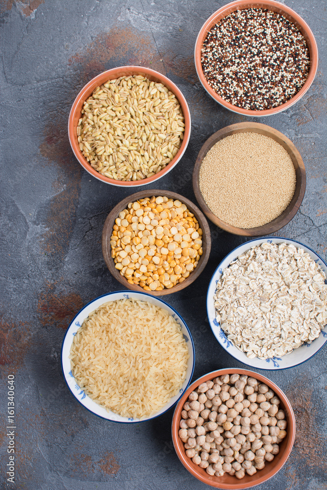 Different grains and cereal on the grey stone background, top view, selective focus Different grains and cereal on the grey stone background, top view, selective focus