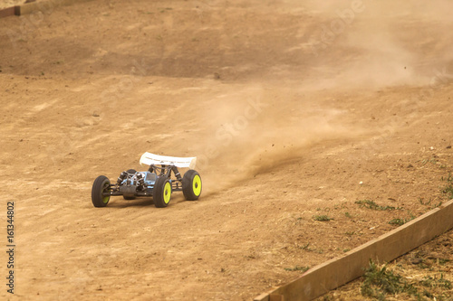 Radio controlled car model in race on dirt track