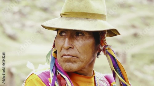 Native quechua man using a chullo and a highlander hat on the mountains of Peru. Slow motion	