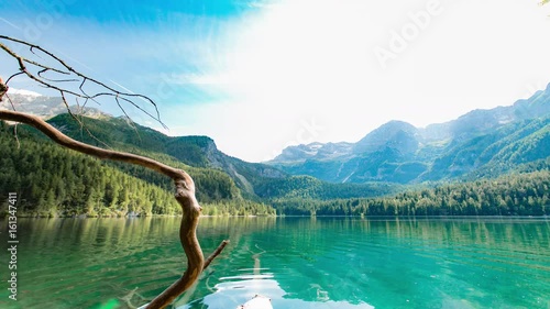 Lake and Mountains LandscapeHyper Time lapse of mountain lakeBeautiful clear blue mountain lake with large mountains in the background on a sunny day - Lago di Tovel photo