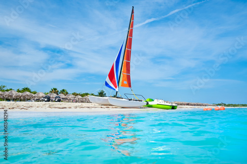 The beautiful beach of Varadero in Cuba with a colorful sailboat