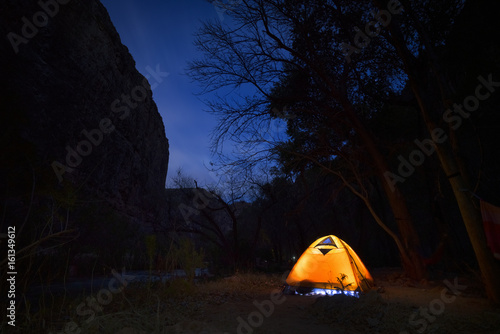 Obraz na plátne Camper with light on in tent under night sky Grand Canyon Arizona