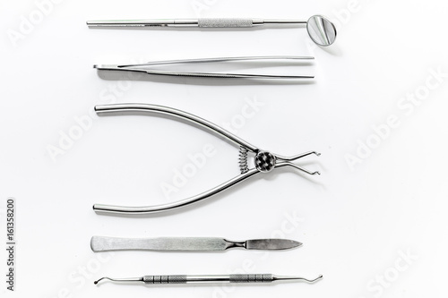 teeth care with dentist instruments in doctor's office white background top view