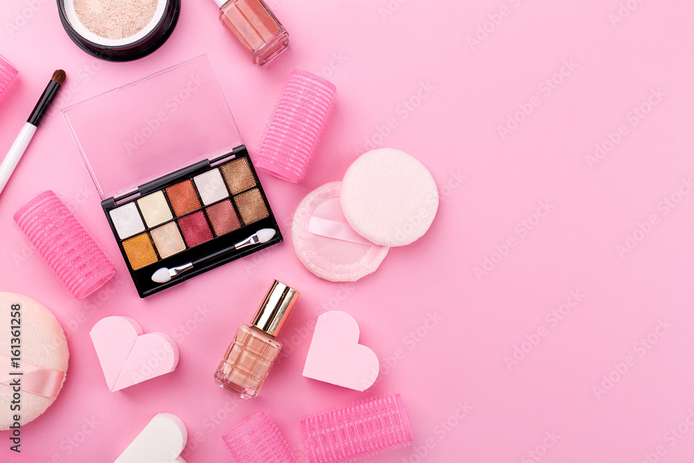 Fototapeta premium Beauty Spa Feminine Concept. Different Make Up Beauty Care Essentials Cosmetics on Flat Lay Pink Background. Top View. Above.
