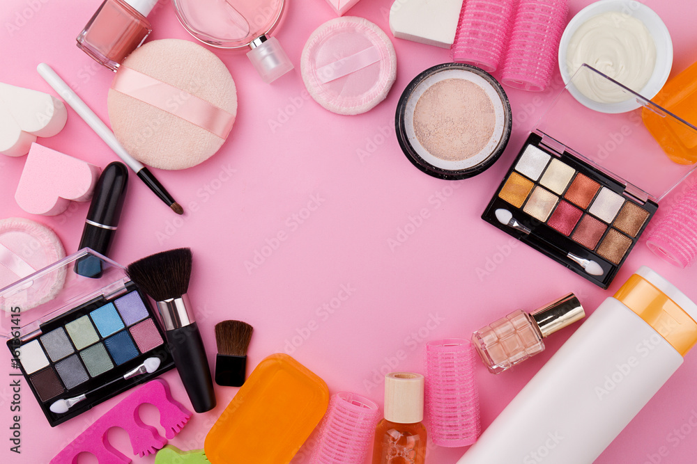 Fototapeta premium Beauty Spa Feminine Concept. Different Make Up Beauty Care Essentials Cosmetics on Flat Lay Pink Background. Top View. Above.