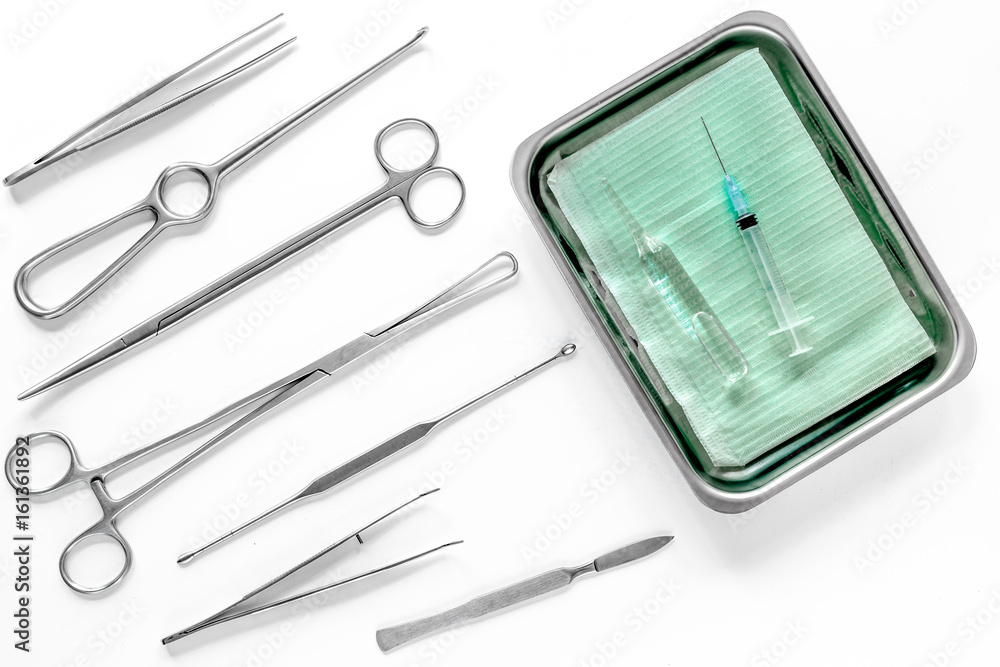 Surgical instruments and tools including scalpels, forceps and tweezers on white table top view