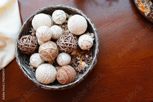 Wicker bowl with wicker balls. Decorative object asian wooden wicker spheres lay in wooden bowl