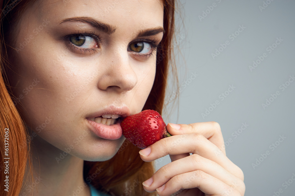 Woman with strawberry, sweet strawberry, woman eating strawberries on gray background portrait Woman with strawberry, sweet strawberry, woman eating strawberries on gray background portrait