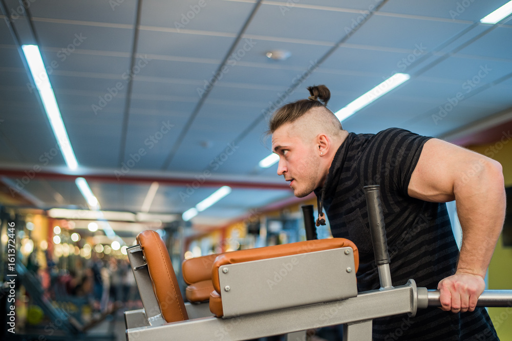 Focused man doing dips in the gym