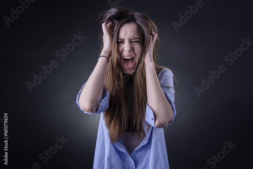Photos Maniac woman screaming, angry and frustrated, white background, very long hair