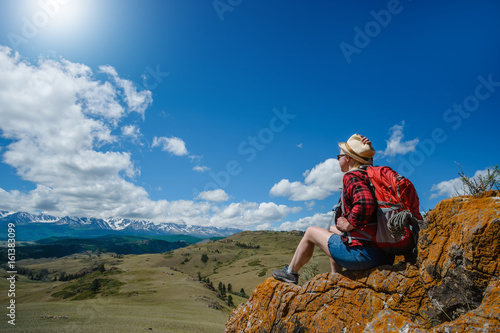 Young woman sitting in a National Park. Dream, looking at the mountains.