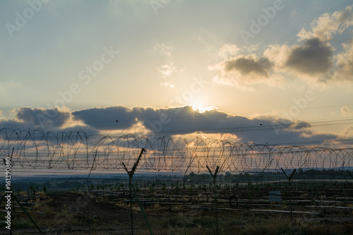 blade fence border under sky near sunset and clouds