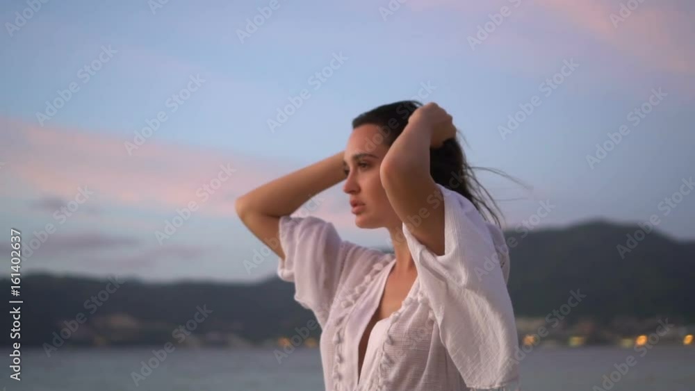 Closeup portrait of sensual woman in white linen dress posing on the sandy beach on tropical paradise island with beatiful summer sunset sky - video in slow motion Closeup portrait of sensual woman in white linen dress posing on the sandy beach on tropical paradise island with beatiful summer sunset sky - video in slow motion