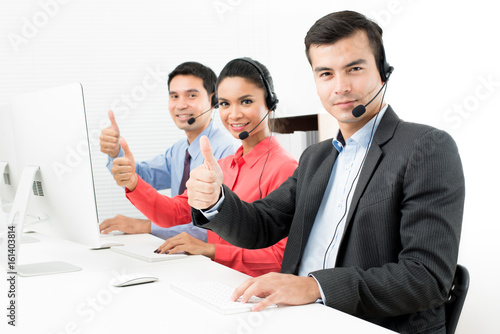 Call center (or telemarketer) team giving thumbs up