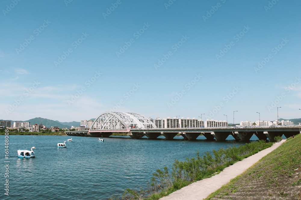 Duck boat and bridge and apartment on riverside park in Chuncheon, Korea