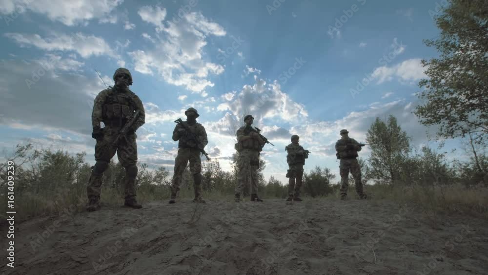 Silhouettes of cool soldiers standing in nature in a row. Silhouettes of cool soldiers standing in nature in a row.
