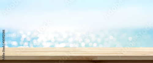 Wood table top on blue summer sparking sea water bokeh banner background