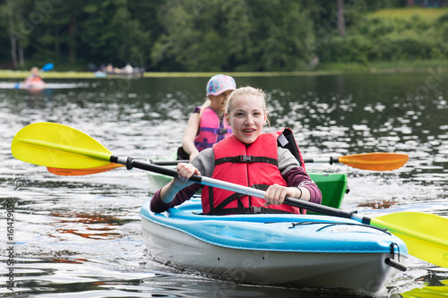 Fényképezés Young kids paddling on a kayak