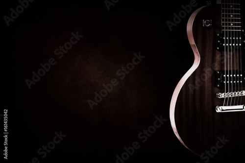 Part of the red electric guitar on black background. A place for writing of the text.