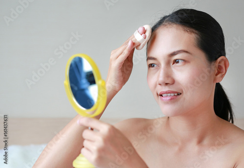 woman applying makeup with Sponge Powder Puff. Woman make up herself.