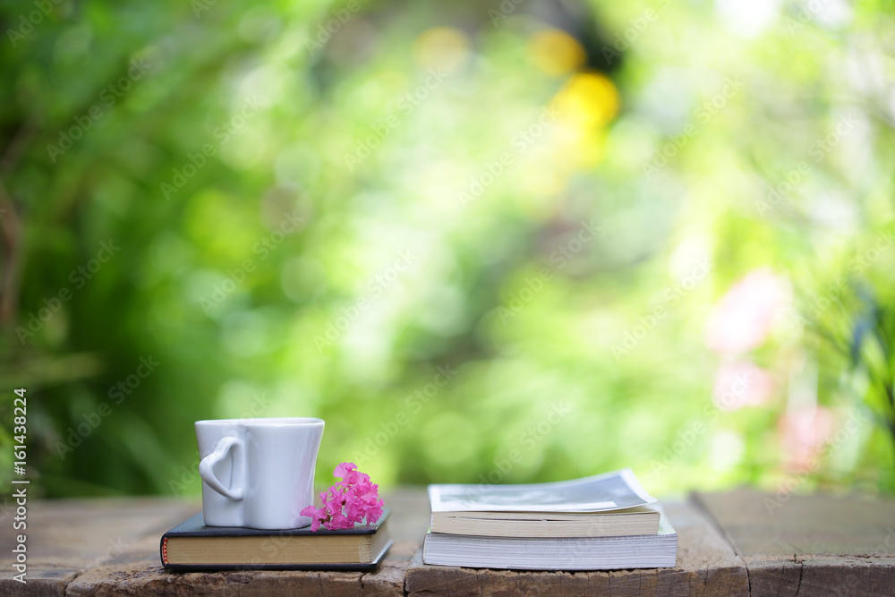 Notebook with pink flower and cup on wooden table Notebook with pink flower and cup on wooden table