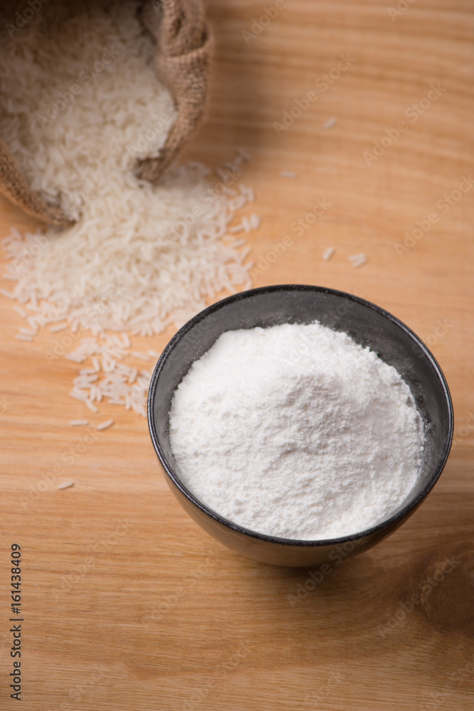 Jasmine white rice in sack and rice flour on wooden table. Jasmine white rice in sack and rice flour on wooden table.