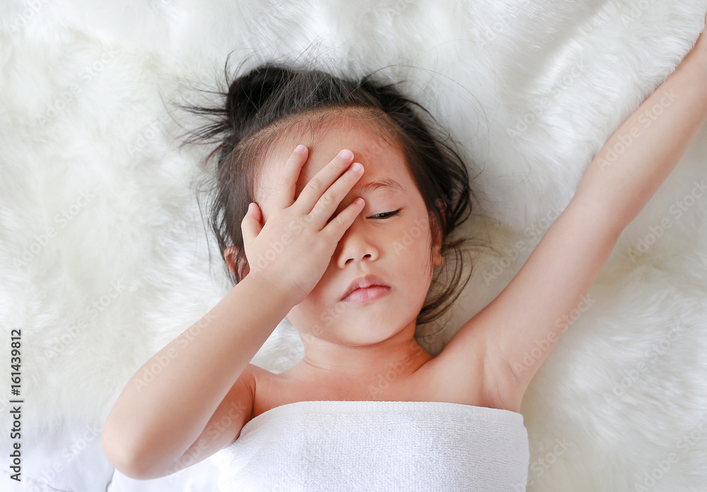 child girl in towel lying on the bed at the morning. child girl in towel lying on the bed at the morning.