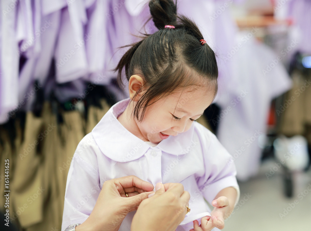 Mother try dressing school uniform for her daughter, Kindergarten children. Mother try dressing school uniform for her daughter, Kindergarten children.