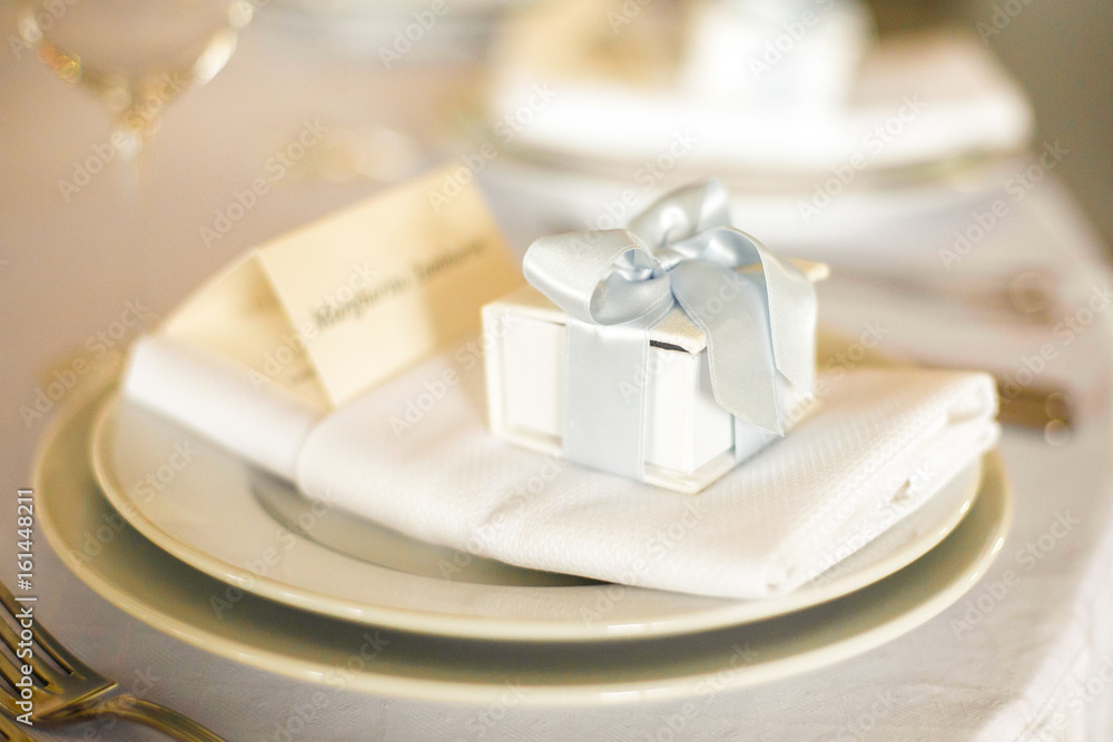 Little present box stands on the white dinner plate Little present box stands on the white dinner plate