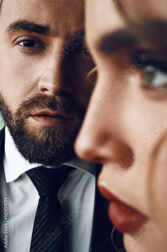 Profile of a woman with red lips standing before a man