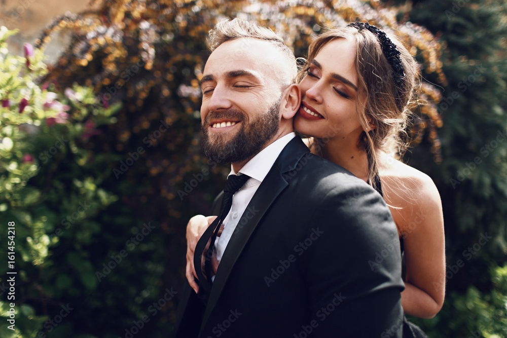 Happy couple in black clothes hugs each other tender outside Happy couple in black clothes hugs each other tender outside