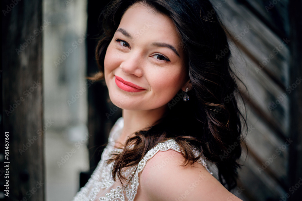 Fototapeta premium Stunning young bride poses before an old wooden door