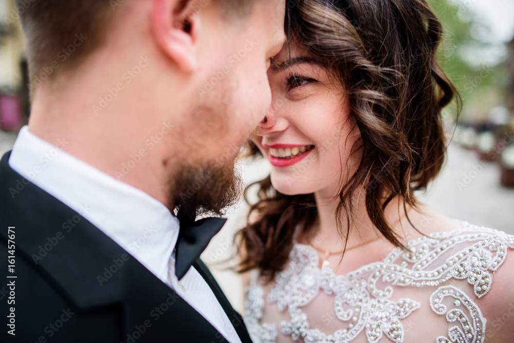 Smiling brunette bride looks in groom's eyes Smiling brunette bride looks in groom's eyes