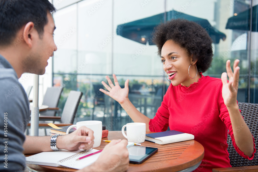 Happy afro woman talking with friend in cafe Happy afro woman talking with friend in cafe