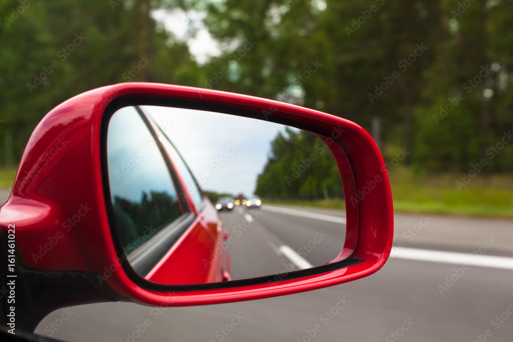 Highway Rear View / View back to road through red side mirror at car