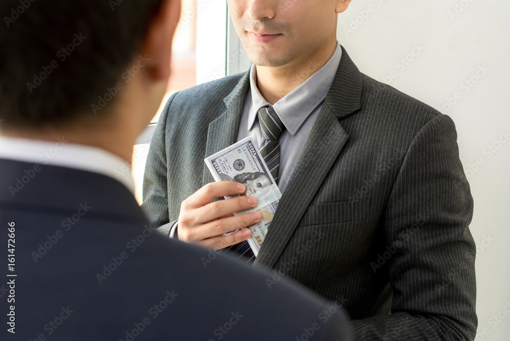 Businessman putting money into his suit pocket