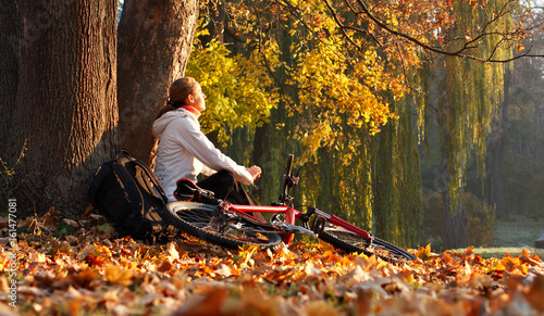Woman cyclist relaxing illuminated by the rays of the rising sun