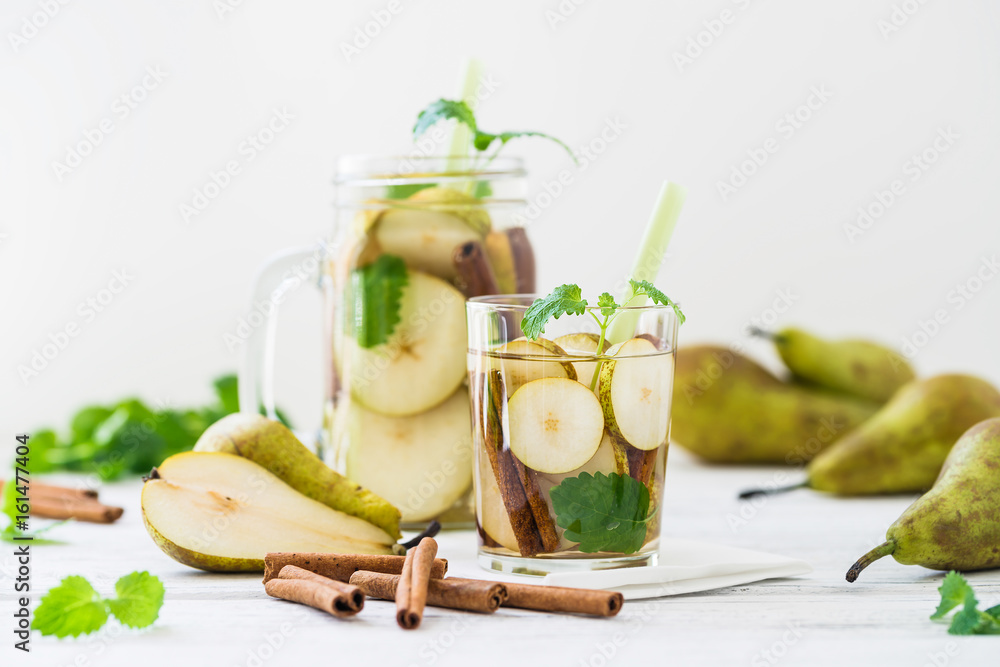 Fototapeta premium Refreshing drink with pear, cinnamon on white rustic table