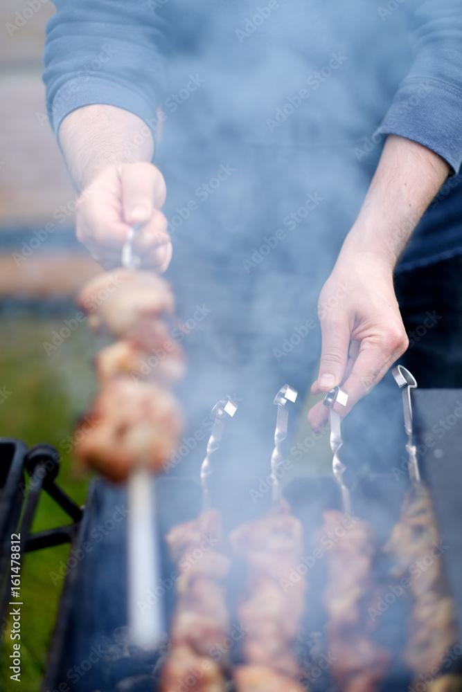 Fototapeta premium Preparation of kebab in a brazier at a picnic