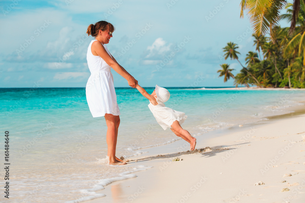 mother and daugher playing on tropical beach mother and daugher playing on tropical beach