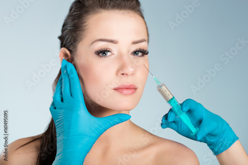 Young beautiful woman getting face injection