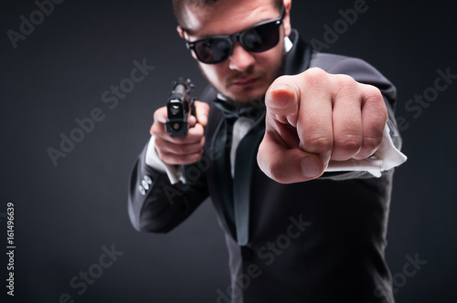 Young criminal or gangster with armed pistol