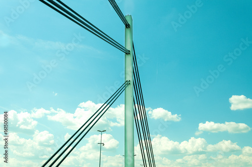 Fototapeta Naklejka Na Ścianę i Meble -  Liberty bridge concrete pole and steel security cables with blue sky background. Novi Sad, Serbia. Bright image. Bridge.