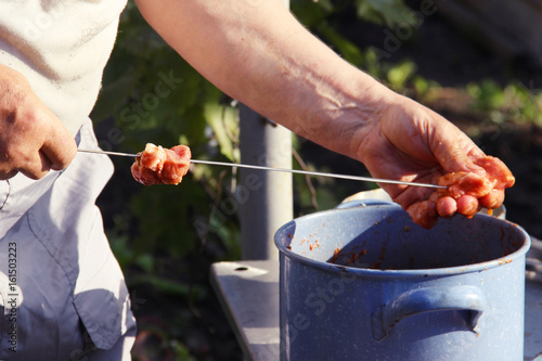 Man stringing meat on a skewer. Shashlik - cooking barbecue. Stringing meat on ramrod. photo